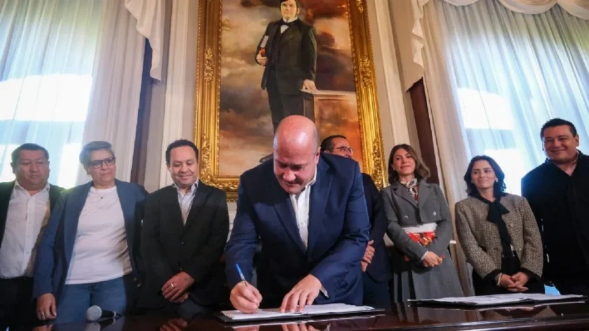 a man in a suit signing a document