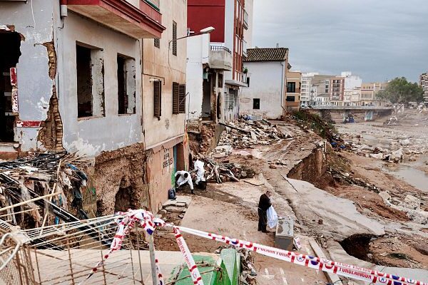 a person standing in front of a destroyed building