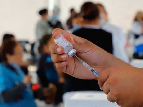 a person holding a syringe and a bottle