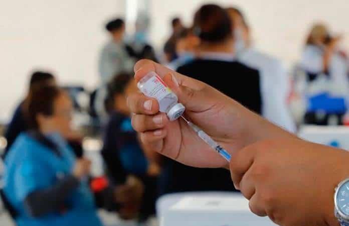 a person holding a syringe and a bottle